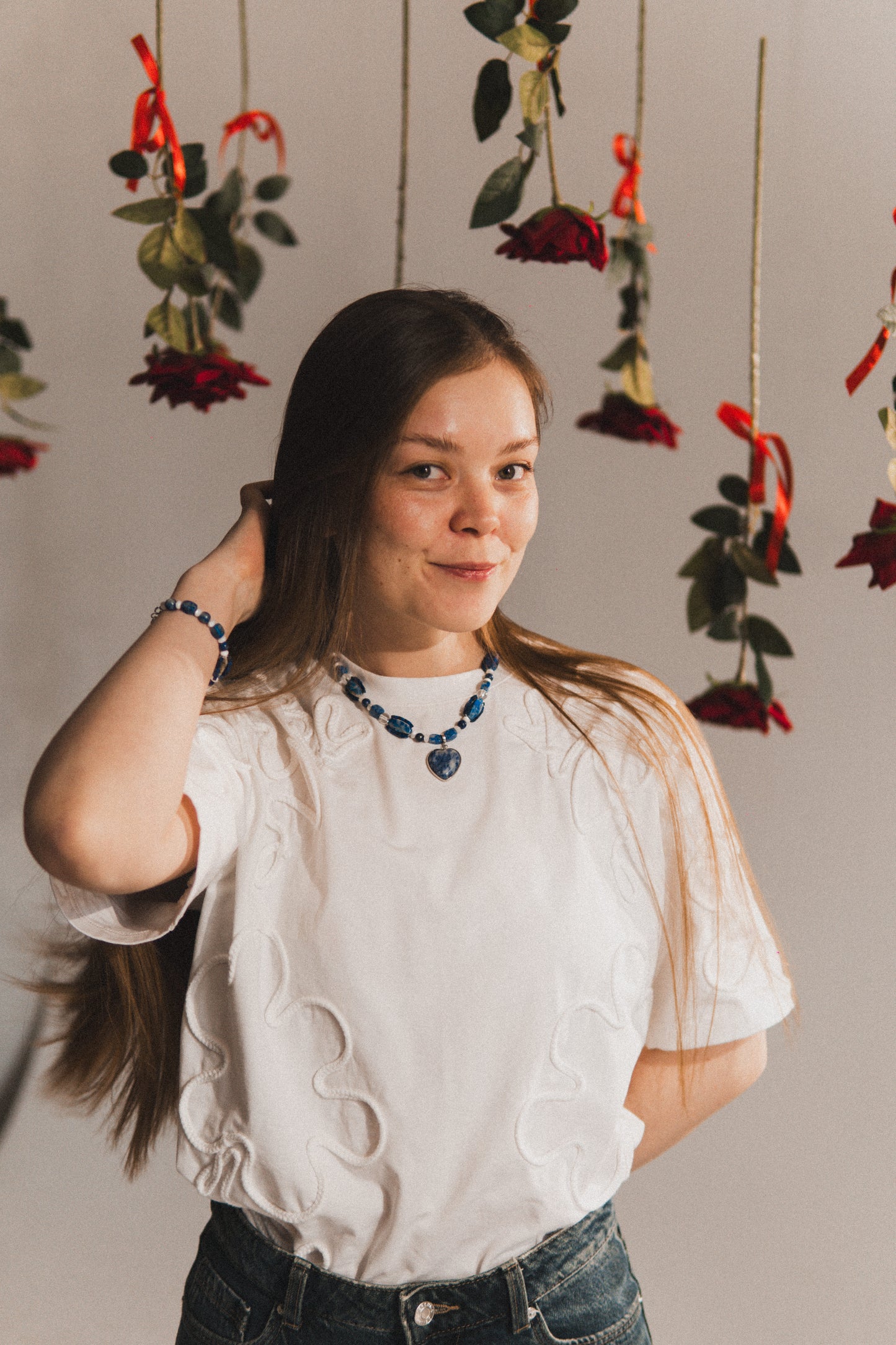 Woman posing with hanging floral decorations in the background