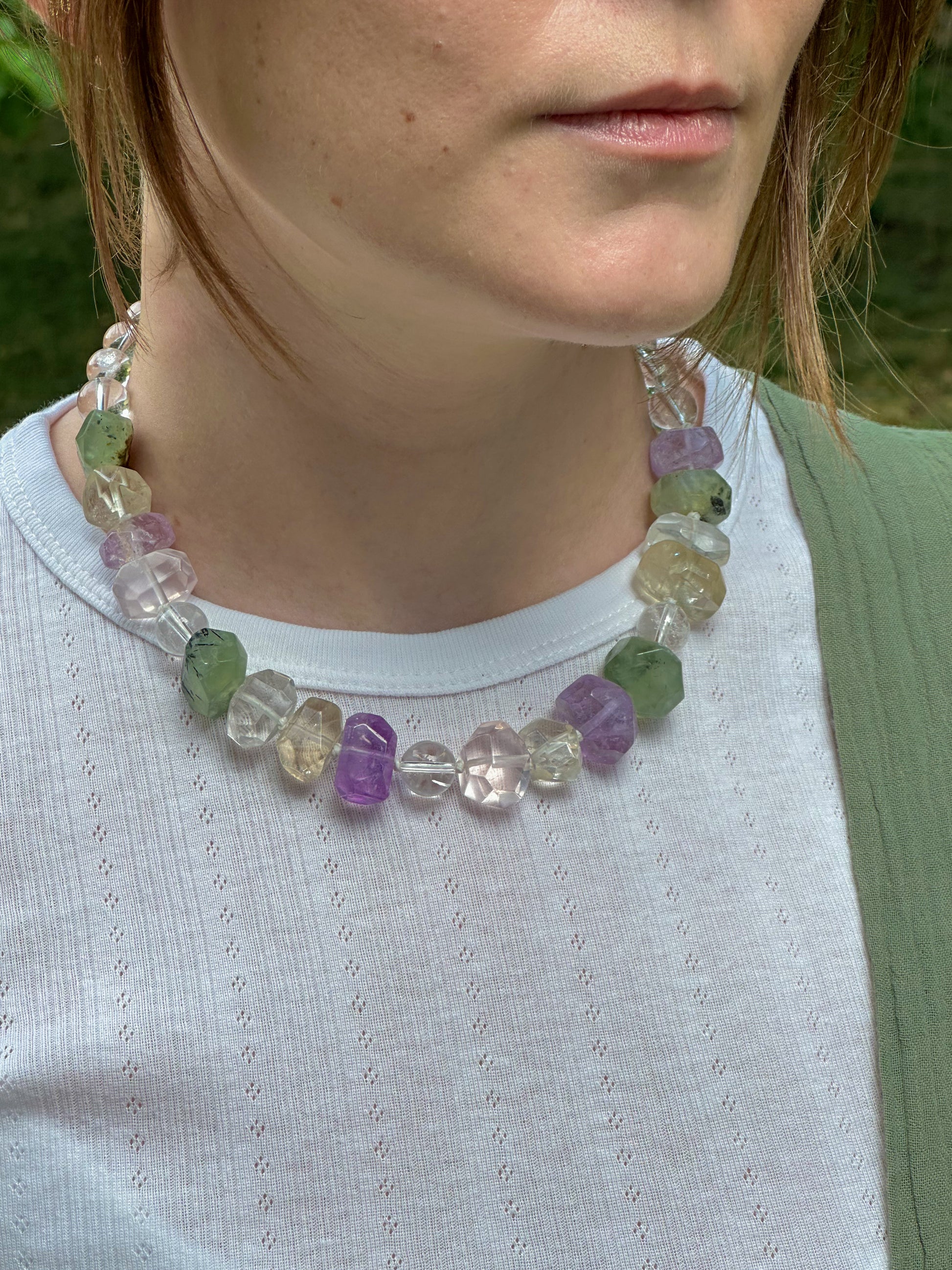 Person wearing a colorful beaded necklace outdoors