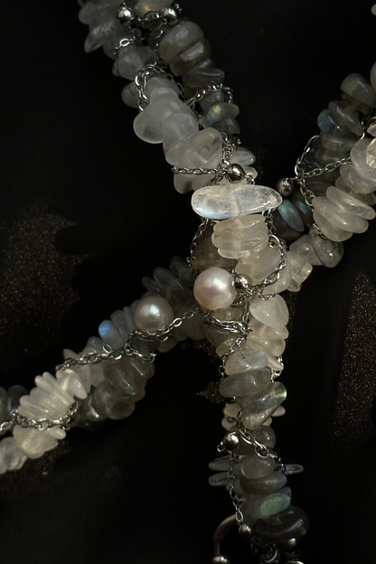 Close-up of a necklace with stones and pearls on a dark background