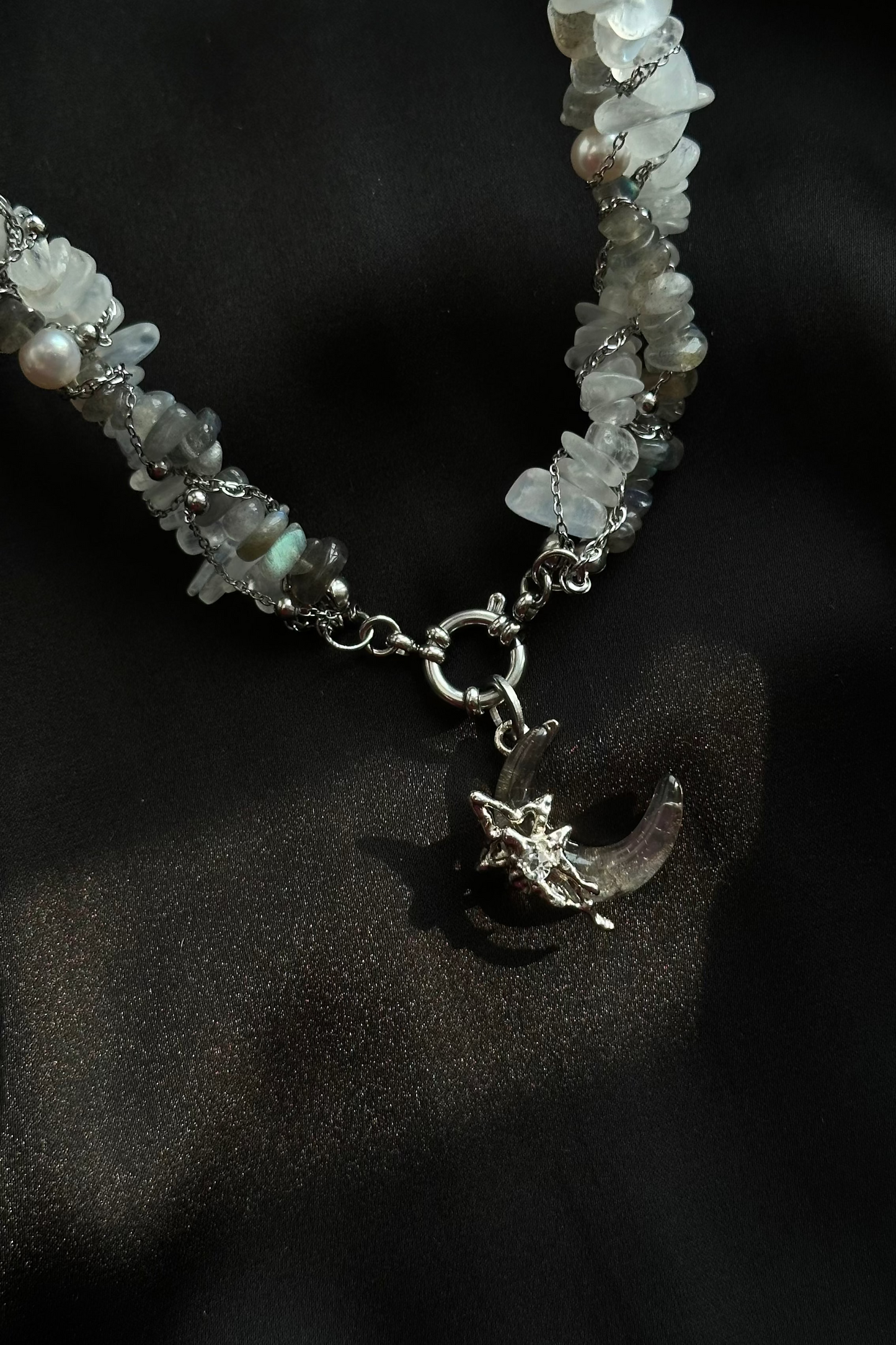 Necklace with moon and star charm on a dark background
