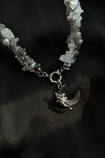 Necklace with moon and star charm on a dark background