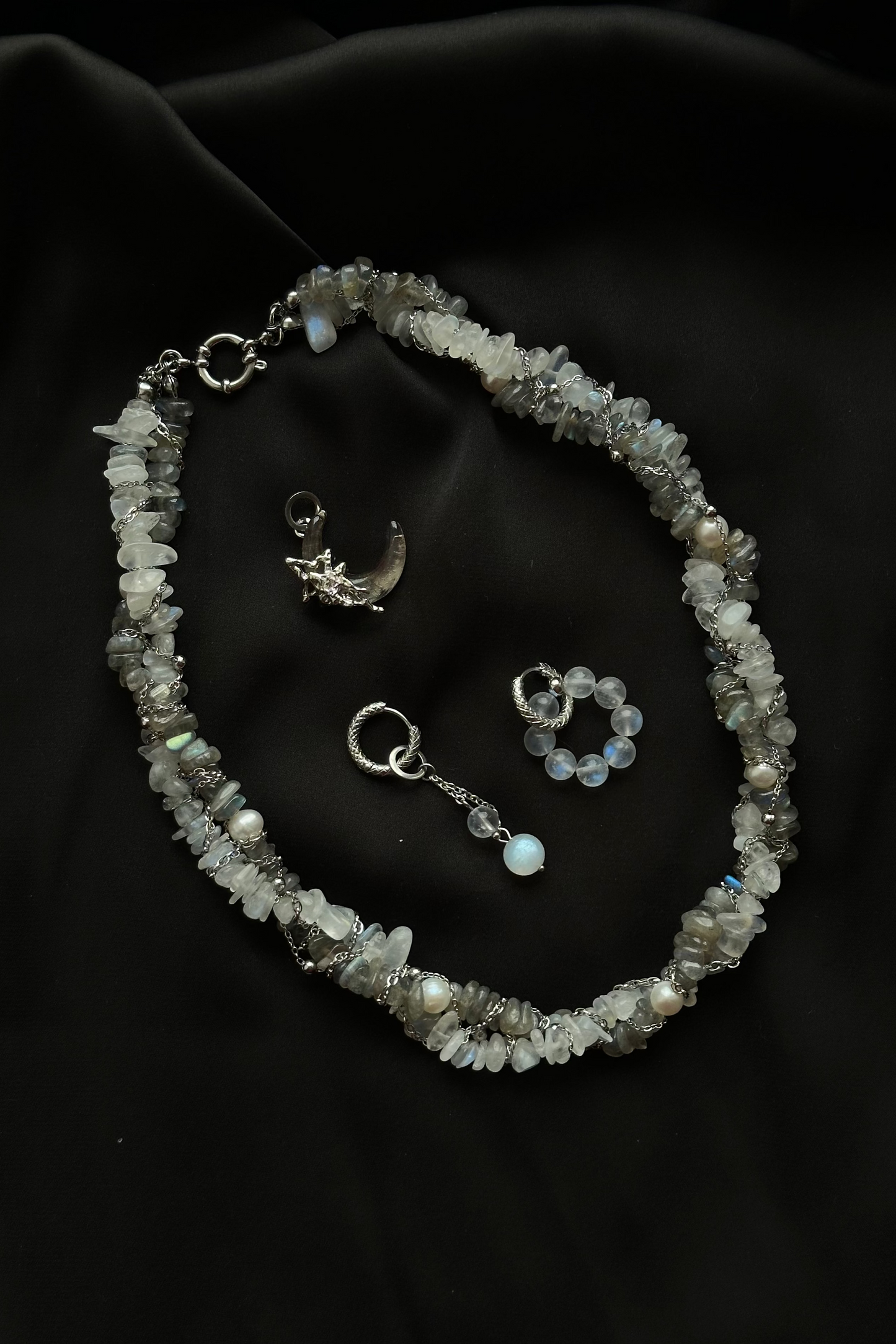 Necklace with pendant and ring on a dark fabric background