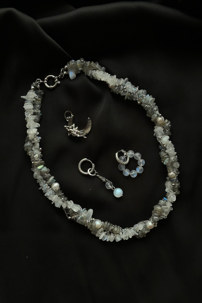 Necklace with pendant and ring on a dark fabric background