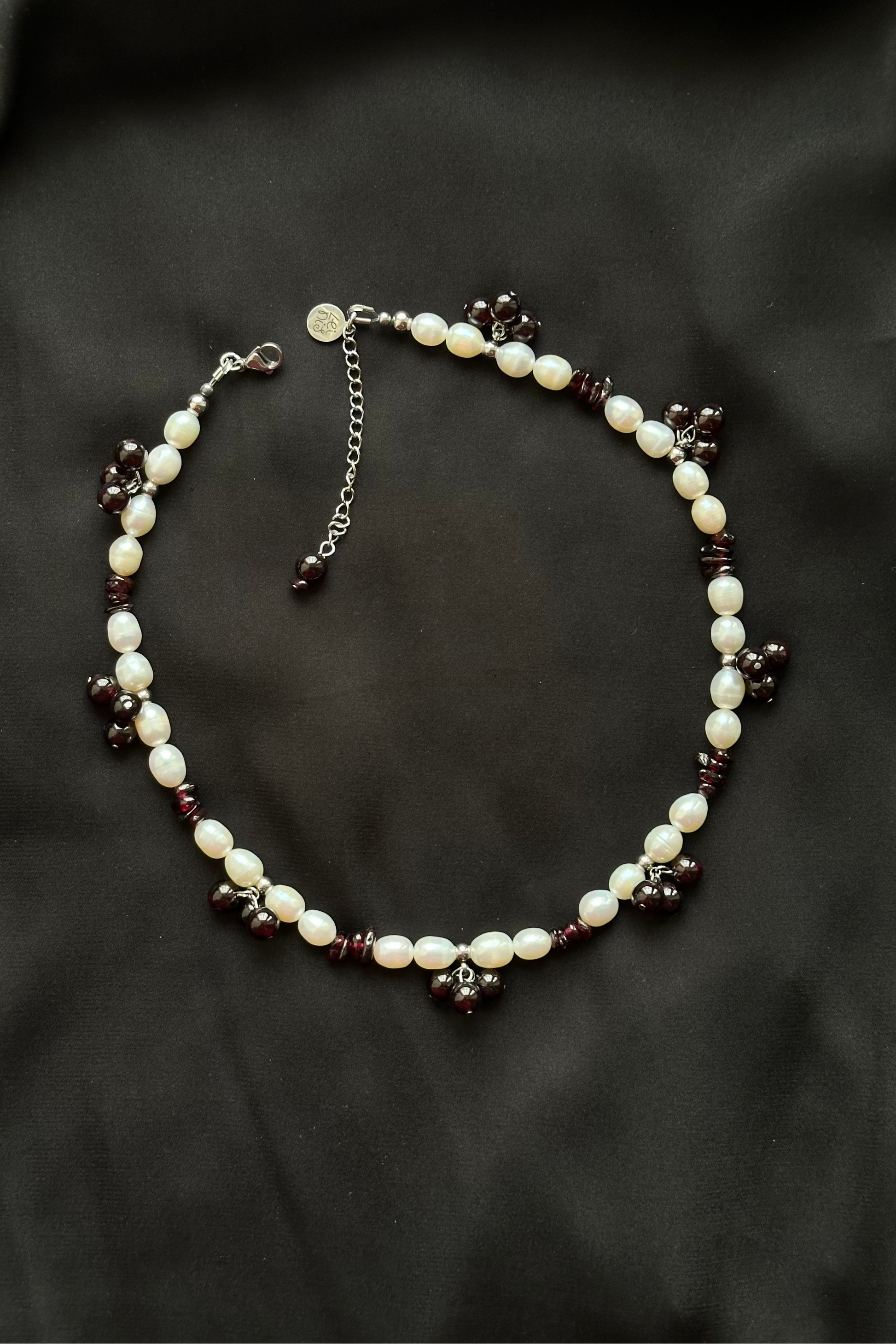 Pearl and dark bead necklace on a black background