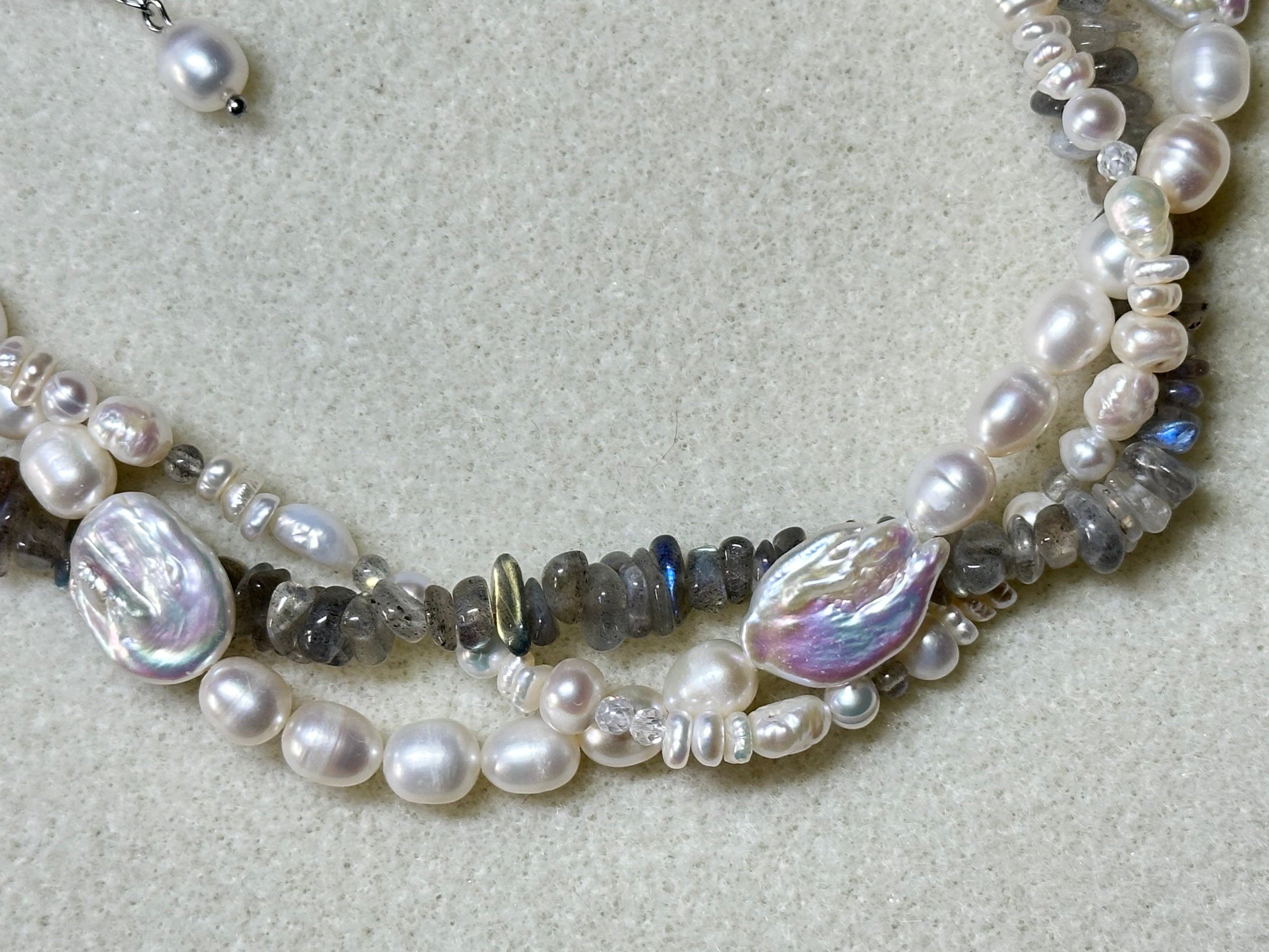 Necklace with pearls and beads on a light gray background