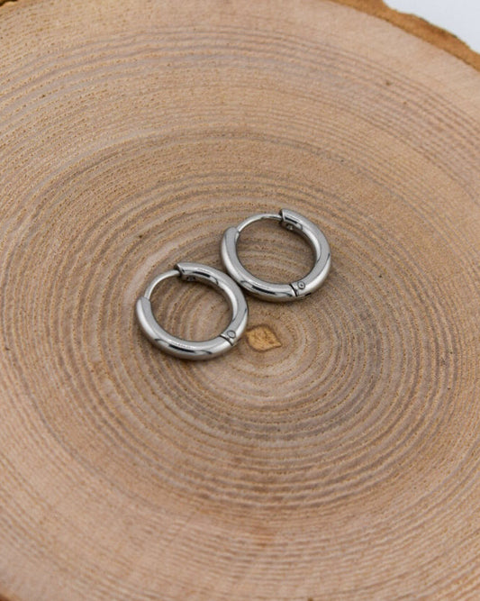 Silver hoop earrings on a wooden surface