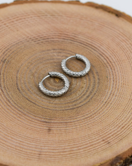 Silver hoop earrings on a wooden surface