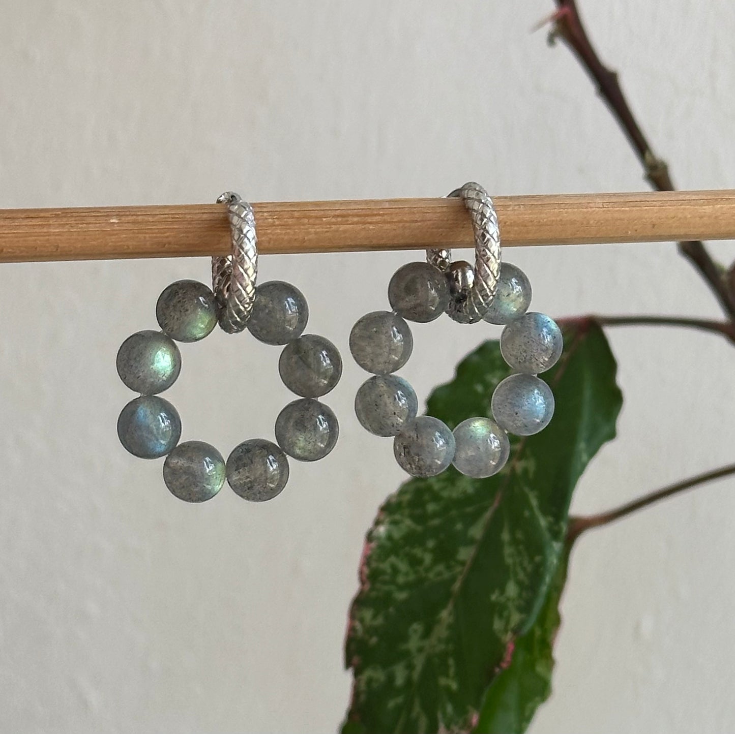 Beaded earrings on a stick with a leafy background