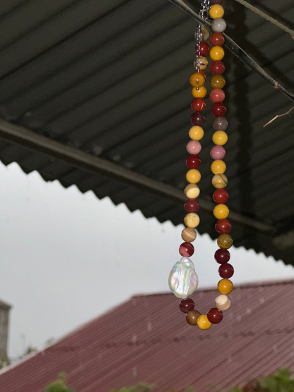 Beaded necklace with a large pearl pendant hanging from a roof