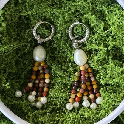 Pair of beaded earrings on a green moss background
