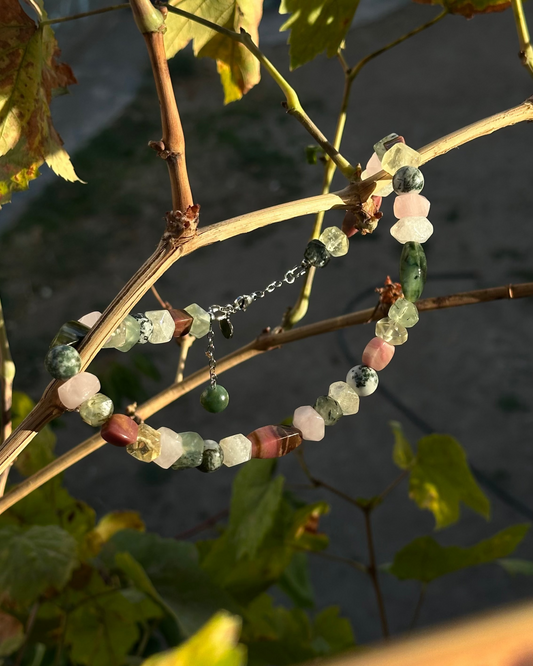 Bracelet with multicolored beads on a branch with leaves