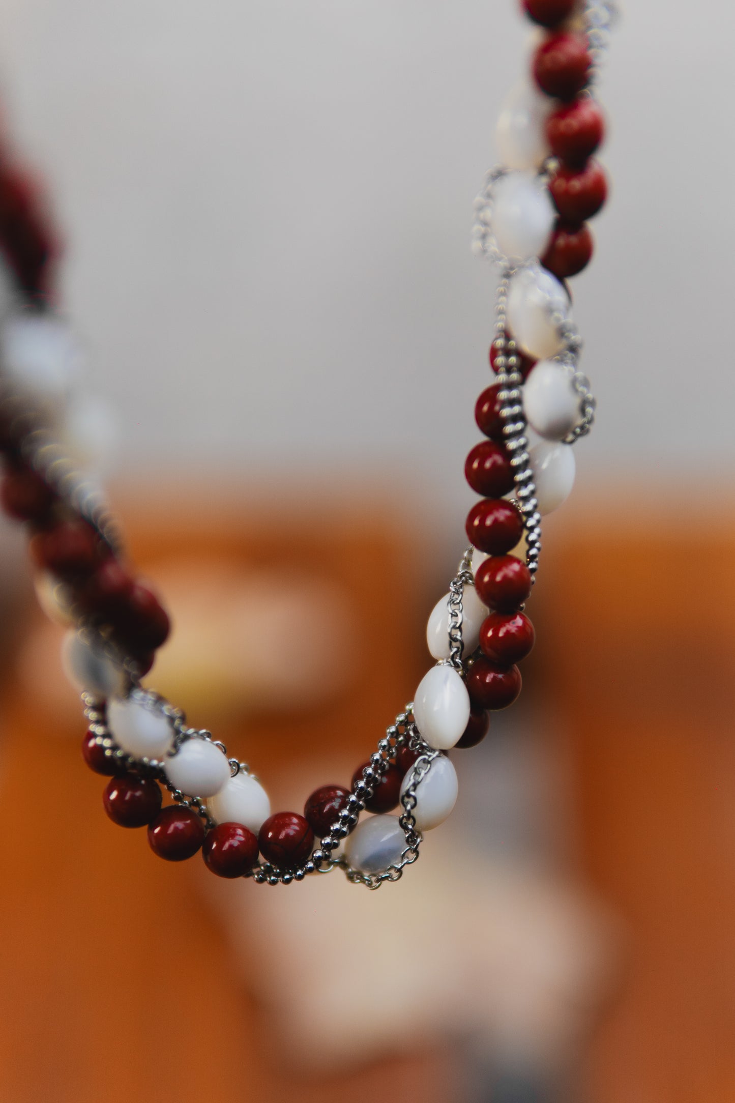 Necklace with red and white beads on a blurred background