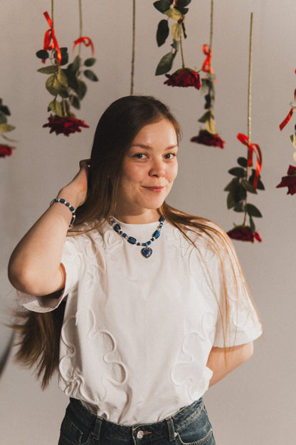 Woman posing with hanging floral decorations in the background