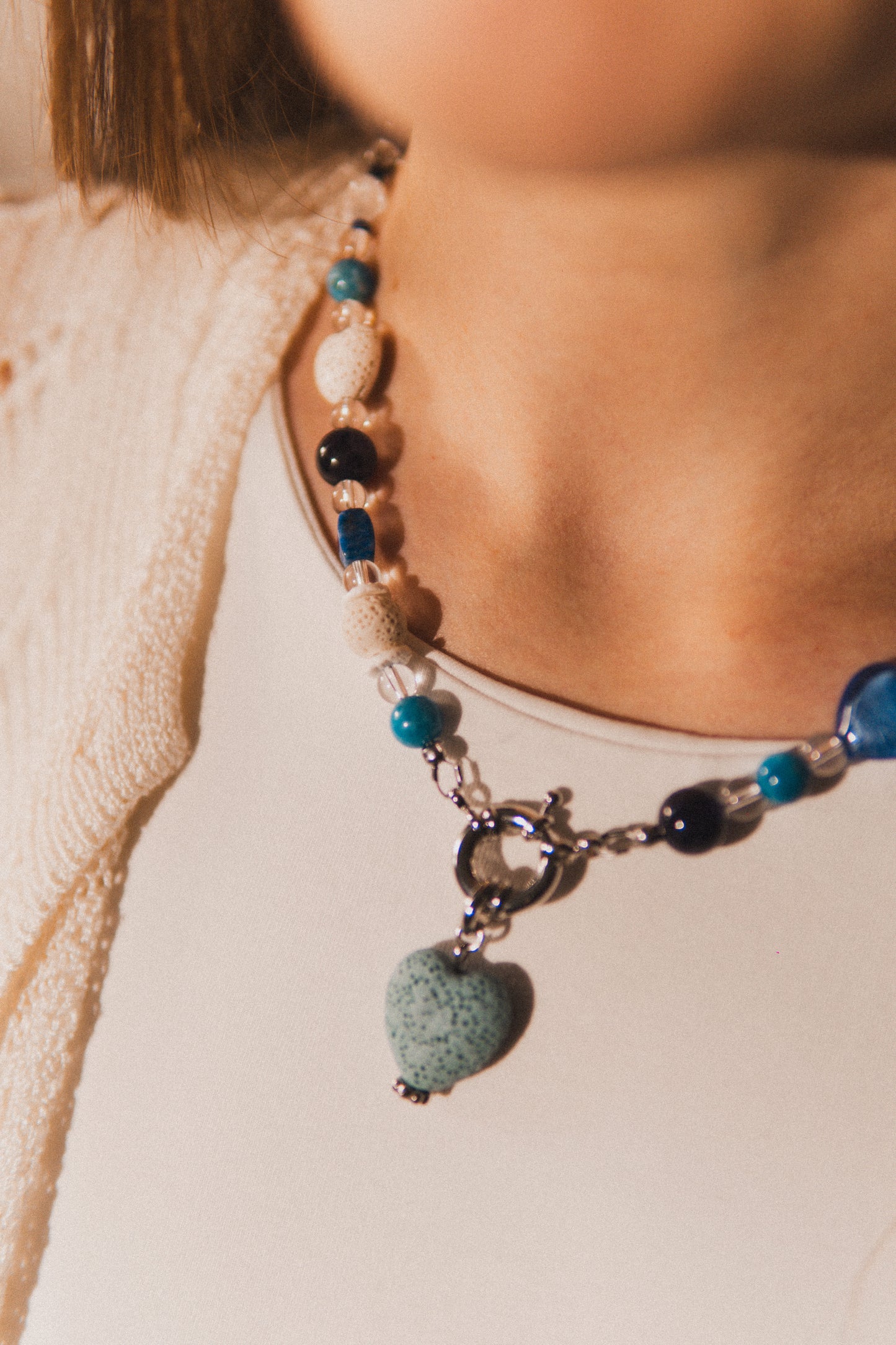 Necklace with blue and green beads worn by a person